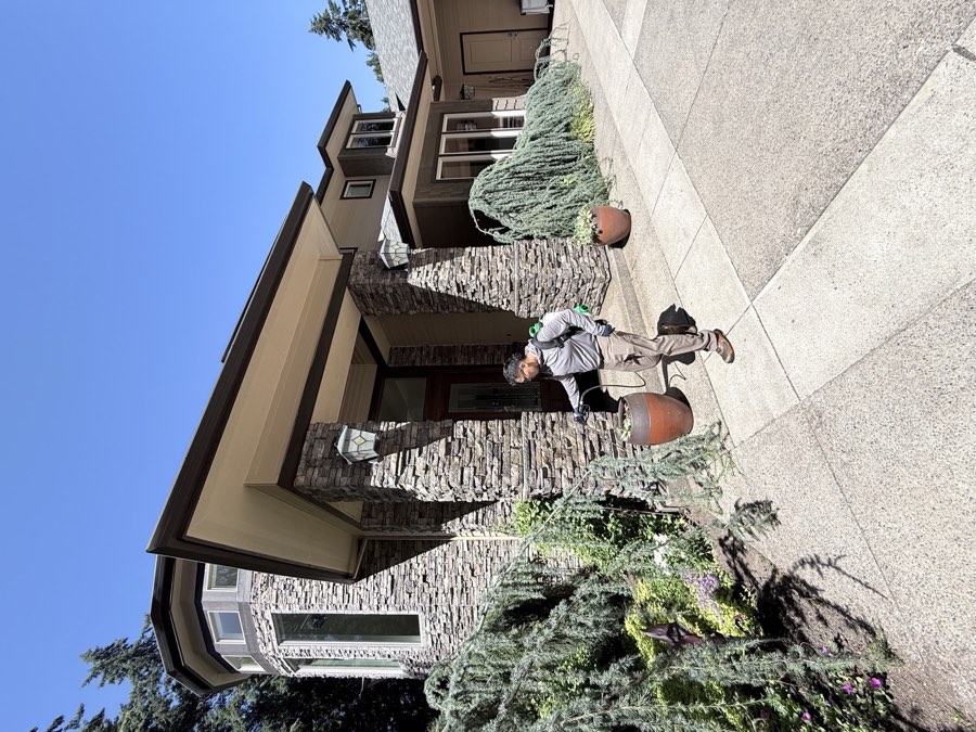 Affordable Pest Pros technician performing perimeter pest control at a local home